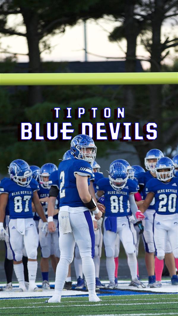 Football team with Blue Devils logo behind them