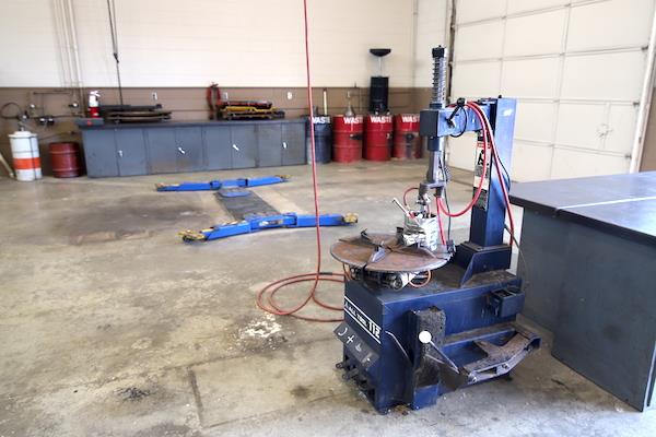 a machine in the auto shop--it is blue and has a cable hanging by it