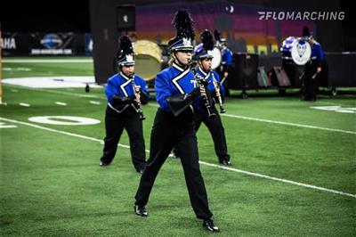 Members of the band are shown in classy uniforms. They march on bright green turf.