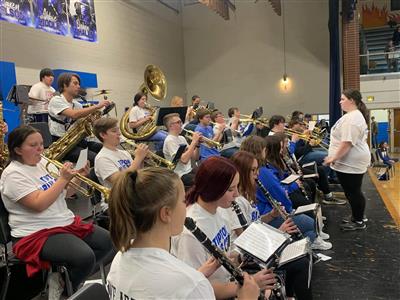 The pep band is shown performing at a basketball game. 